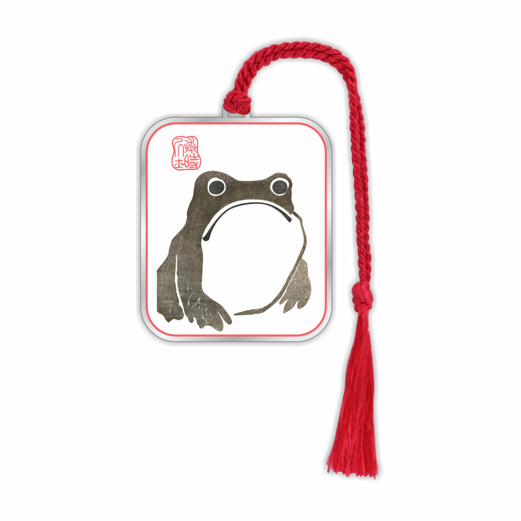 Metal bookmark inspired by Matsumoto Hoji’s frog print featuring a minimalist Japanese frog design symbolizing good luck, prosperity, and wabi-sabi aesthetics of simplicity and imperfection with red braided tassel.