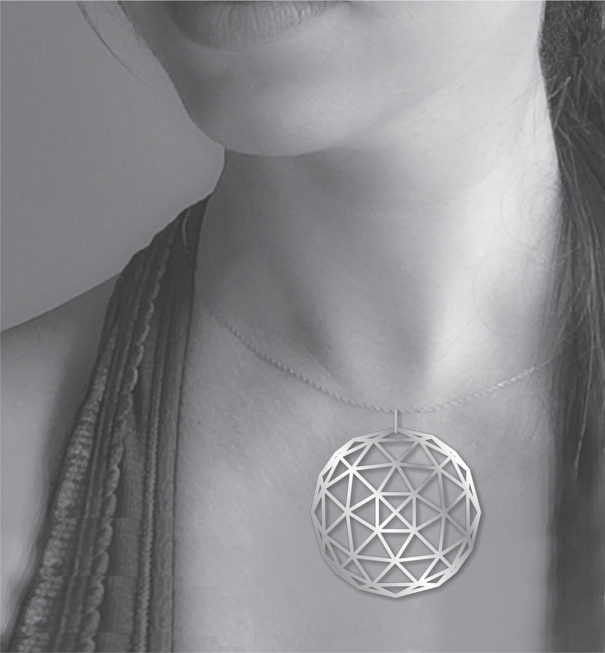 Geodesic Dome necklace shown worn on a model, featuring a large silver-tone geometric pendant with an open triangular dome pattern on a delicate chain.