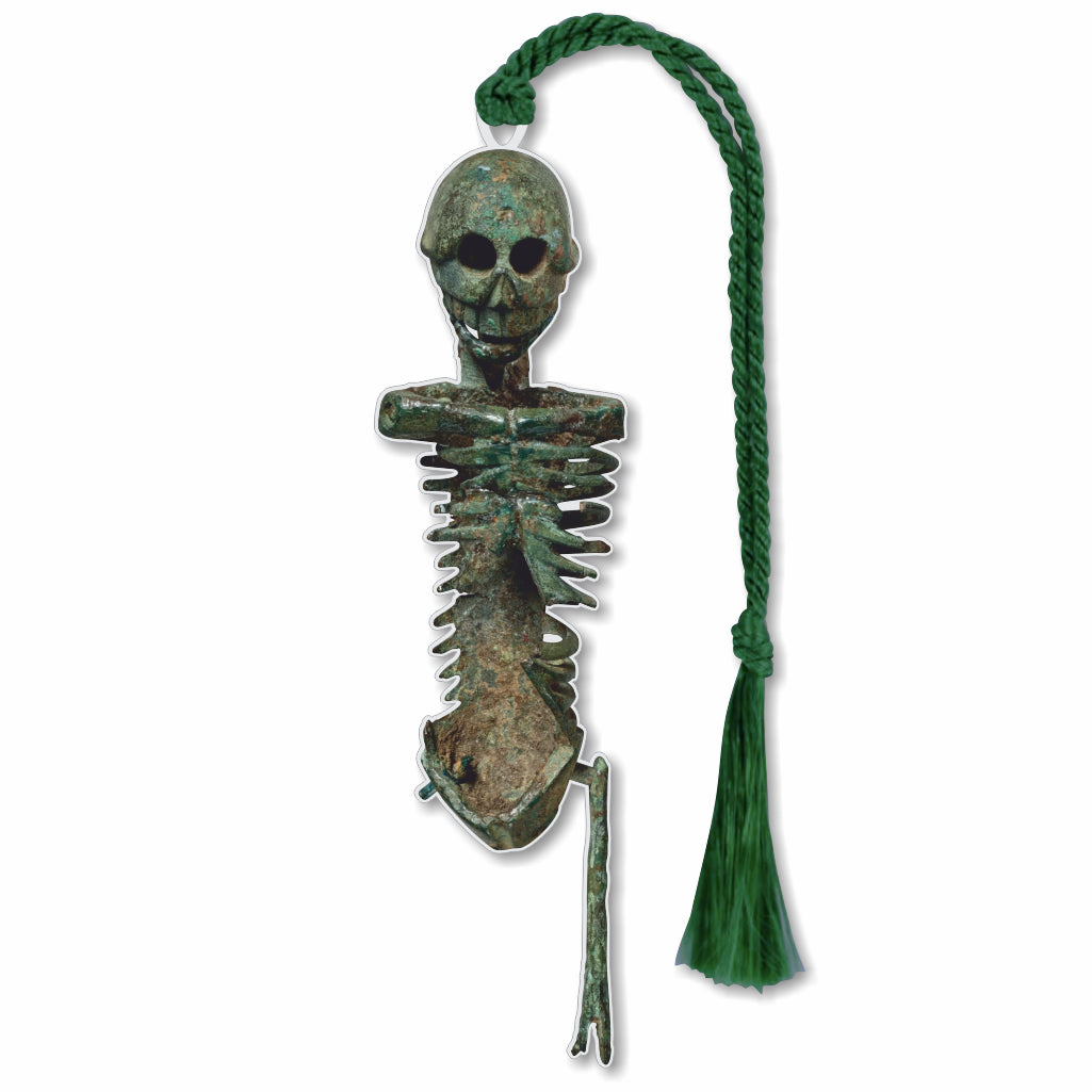 A silver brass bookmark in the shape of a skeleton with one leg and no arms with a green tassel.