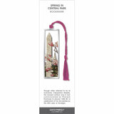Spring in Central Park’ bookmark featuring cherry blossoms and city monument scene, with a pink braided tassel.