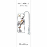 A book bookmark card for 'CAT-E-GOREY' featuring an illustration of a cat on a unicycle in silver and gold tones, with a white tassel, and the name Edward Gorey printed at the bottom.