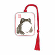 Metal bookmark inspired by Matsumoto Hoji’s frog print featuring a minimalist Japanese frog design symbolizing good luck, prosperity, and wabi-sabi aesthetics of simplicity and imperfection with red braided tassel.