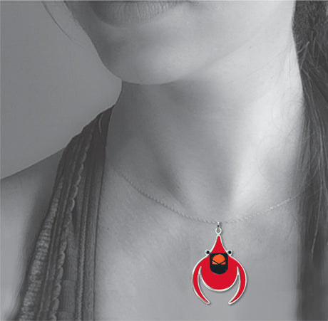 Model wearing the Cardinal pendant necklace featuring a vibrant red stylized bird charm inspired by Charley Harper’s minimalist nature artwork.