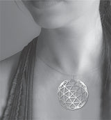 Geodesic Dome necklace shown worn on a model, featuring a large silver-tone geometric pendant with an open triangular dome pattern on a delicate chain.