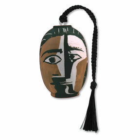 A silver metal bookmark featuring a Picasso geometric abstract design of a face in brown, white, and black, with a black tassel.