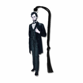 A metal bookmark shaped like Abraham Lincoln with a black tassel, featuring an illustration of Lincoln in his presidential attire.
