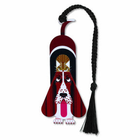 A metal Charley Harper bookmark featuring an artistic depiction of a dog and a cat with a braided black tassel.