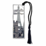 A metal bookmark featuring an image of the Eiffel Tower with two cats and a moon view, attached to a black braided tassel.